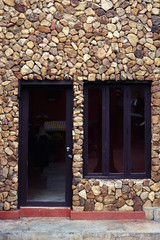 Fototapeta na wymiar Black door and windows on stone wall