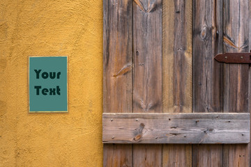 Old wooden door and blank poster on yellow wall
