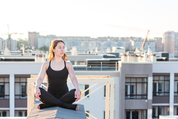 Young woman doing yoga on the roof