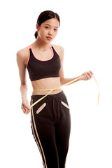 Beautiful Asian healthy girl measuring her waist