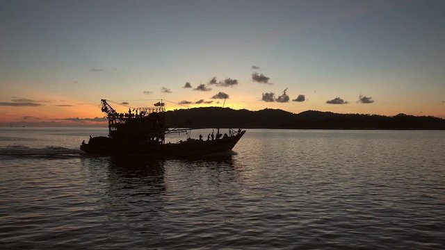 4k Silhouette of fishing boat at sunset in Malaysia