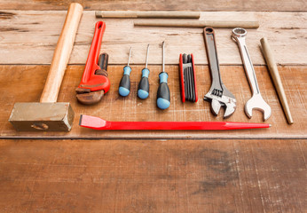 Wrench, screwdriver, Phillips screwdriver, flat crowbar,brass hammer on wood.