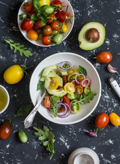 Salad with tomatoes and avocado on a dark background. Top view
