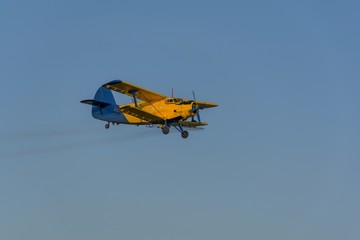 Fototapeta na wymiar Crop duster spraying crops from the air in the morning light