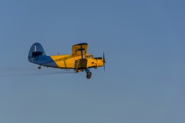 Crop duster spraying crops from the air in the morning light