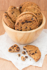 Chocolate chip cookies in a bowl on wooden table.