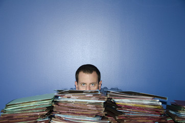 Man hiding behind files.
