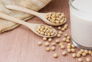Glass with Soy Milk and beans on wooden background