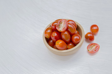 Fresh tomato in wooden bowl with space on white background