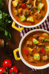 Beef stew served with cooked potatoes.