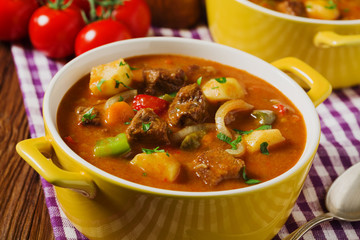 Beef stew served with cooked potatoes.