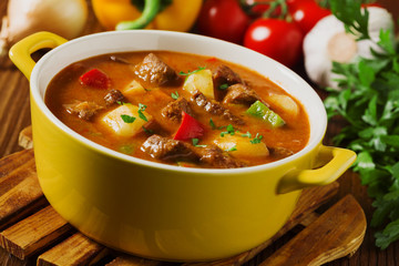 Beef stew served with cooked potatoes.