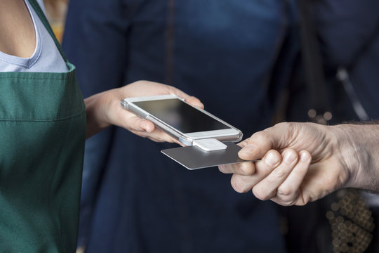 Saleswoman Accepting Payment From Customer In Pet Store