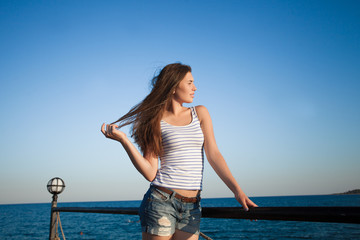 Girl standing on the pier . Beautiful sea background