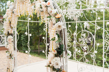 white wedding arch decorated with flower outdoors
