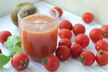 Glass of tomato juice on white background