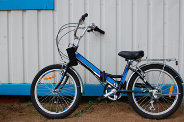Fototapeta na wymiar Modern child kids blue and black bike stand near wall, Sport concept, contrast 