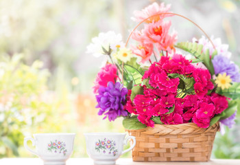 Good morning with good breakfast. Basket with flowers outdoors, blurred background