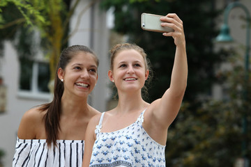 Zwei Freundinnen machen ein Selfie mit dem Smartphone
