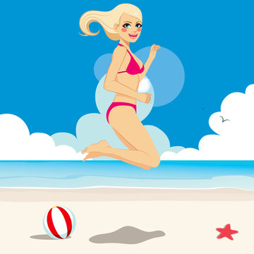 Beautiful blonde girl in bikini jumping happy on the beach