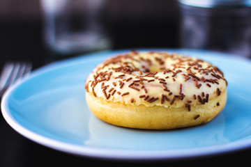 Sweat glezed donut on blue plate on table