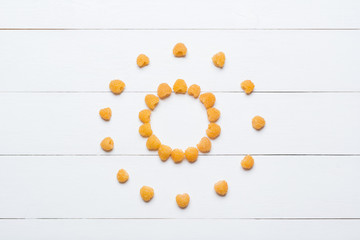 Sun made of yellow raspberries on white wooden table