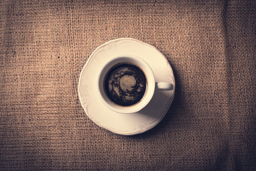 Cup of coffee on sackcloth background