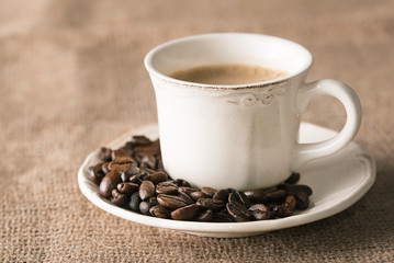 Fresh coffee and coffee beans on sackcloth