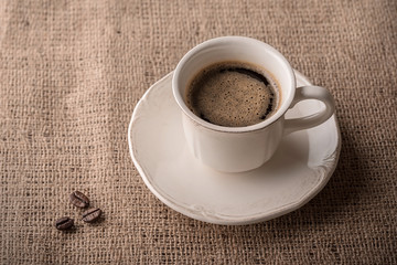 Fresh coffee and coffee beans on sackcloth