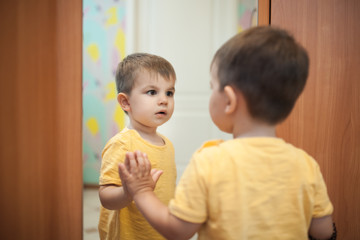 little boy looking at himself near mirror  © goami