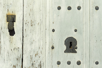 old wooden door with locks and handle of rusty iron , background
