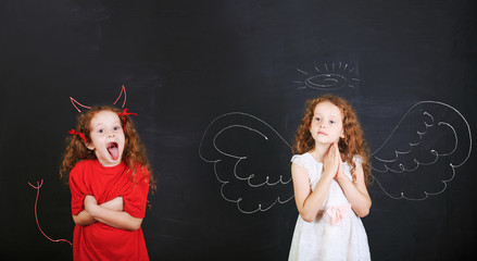 Angry girl with imp horns and tail and a angel girl wings drawn
