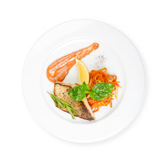 Dish of fish fillet with basil and lemon on plate isolated on white