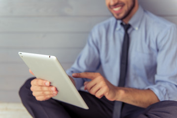 Handsome young businessman with gadget