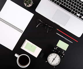 Business's desk Mix of office supplies and gadgets on black wooden table background. Top View from above.