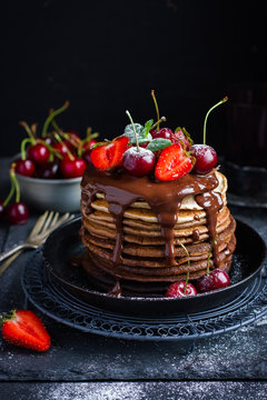 Ombre chocolate pancakes with fresh berries and chocolate sauce