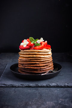 Ombre chocolate pancakes with fresh strawberry on dark backgroun