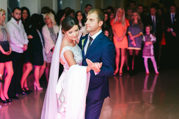Groom looks tired dancing with a beautiful bride