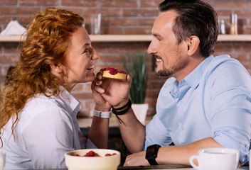 Man looking at woman and holding cake