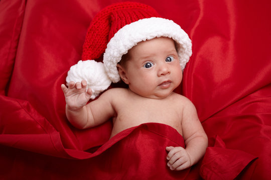 cute baby with santa hat on red background