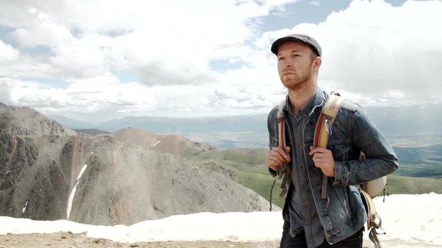 Outdoor portrait of Young man hiking on the mountains,smiling happy portrait of tourist male.extreme sport