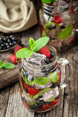 Detox drink with fresh berries in glass jars