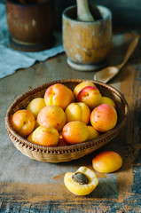 Fresh apricots in the basket on a wooden table in rustic style