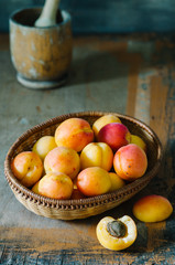 Fresh apricots in the basket on a wooden table in rustic style