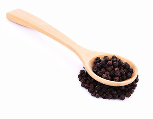 Wooden spoon and black peppercorn on white background