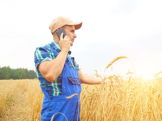 Farmer in a plaid shirt controlled his field. Talking on the pho