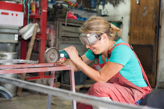 young woman working in metal workshop