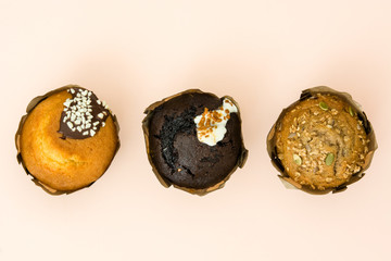 Delicious variety of muffins on brown background

