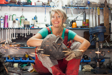 woman mechanic in a workshop  - obrazy, fototapety, plakaty