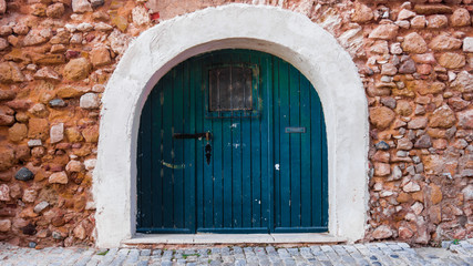Ancient wooden door in old stone  wall.  Wooden Door in Old City